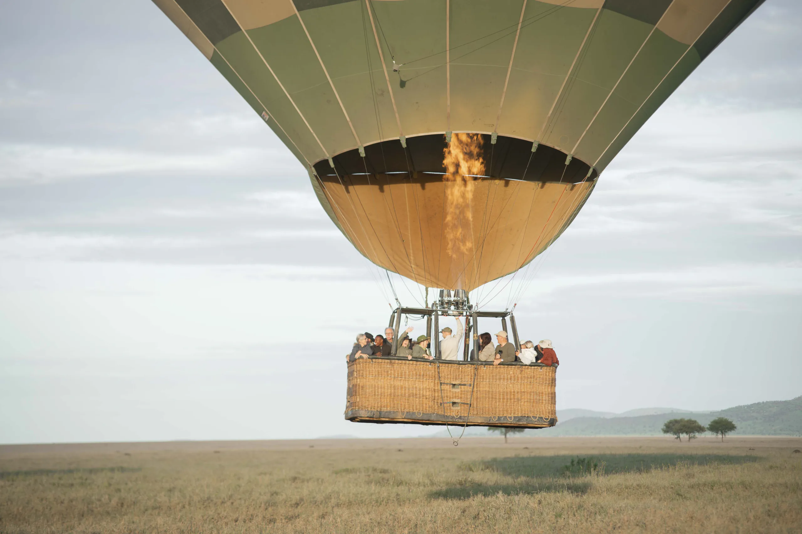A hot air balloon safari rising over the Serengeti at dawn