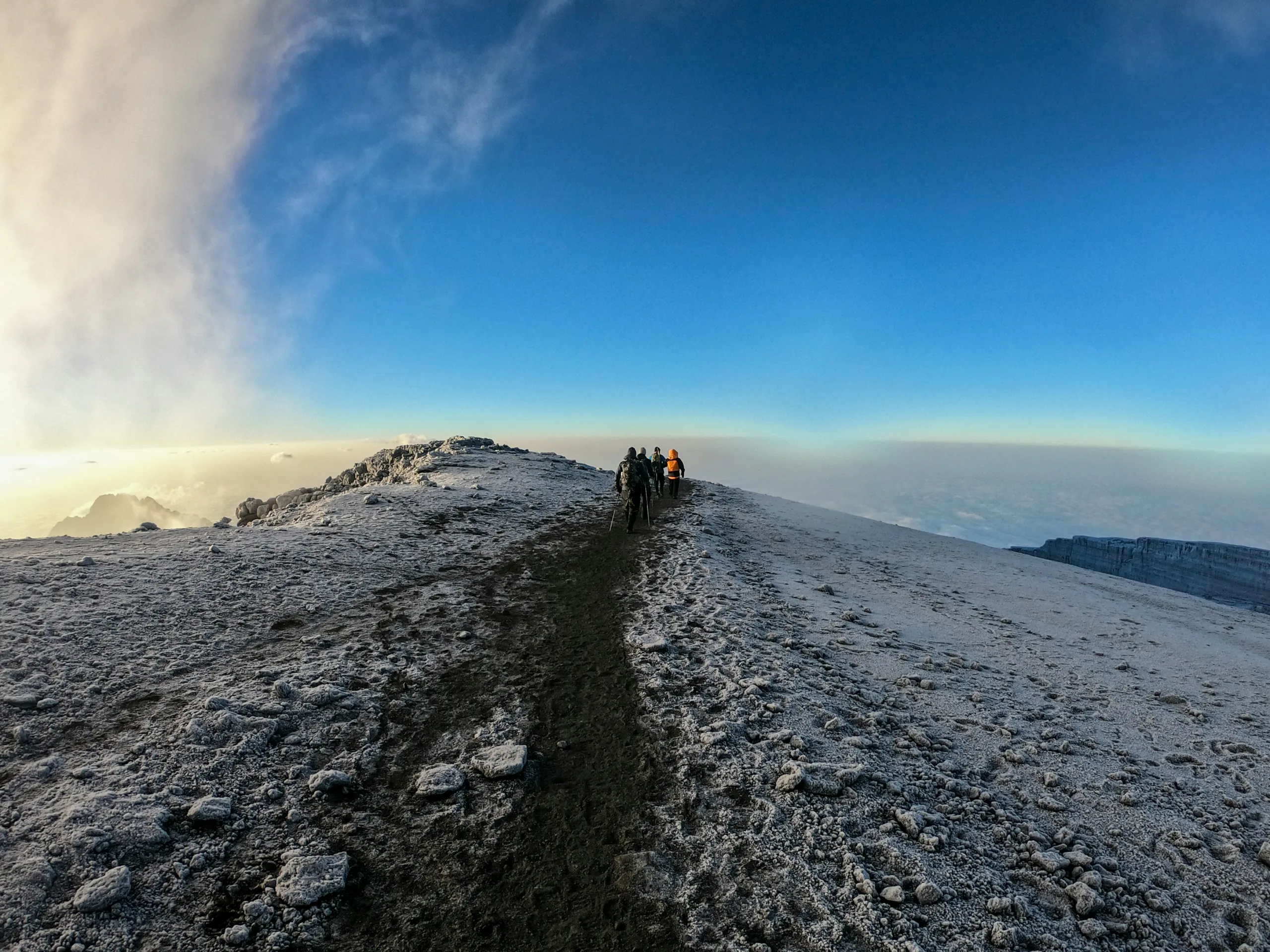 Trekkers walking along Mount Kilimanjaro's summit ridge