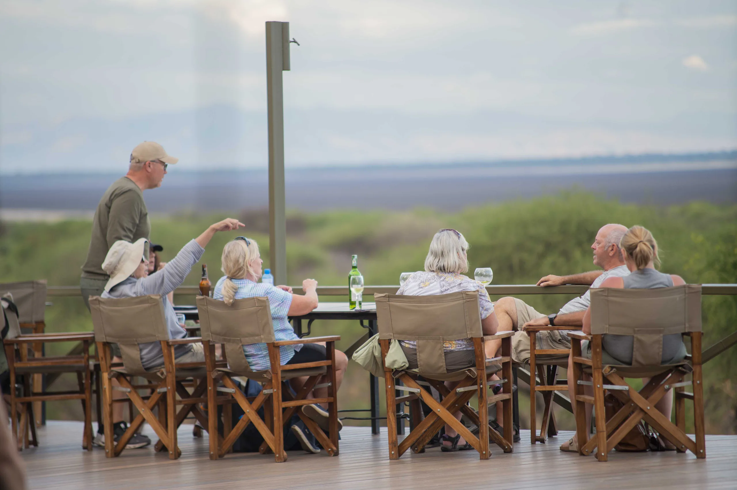 Guests relaxing on a lodge deck with a wide Tanzania view