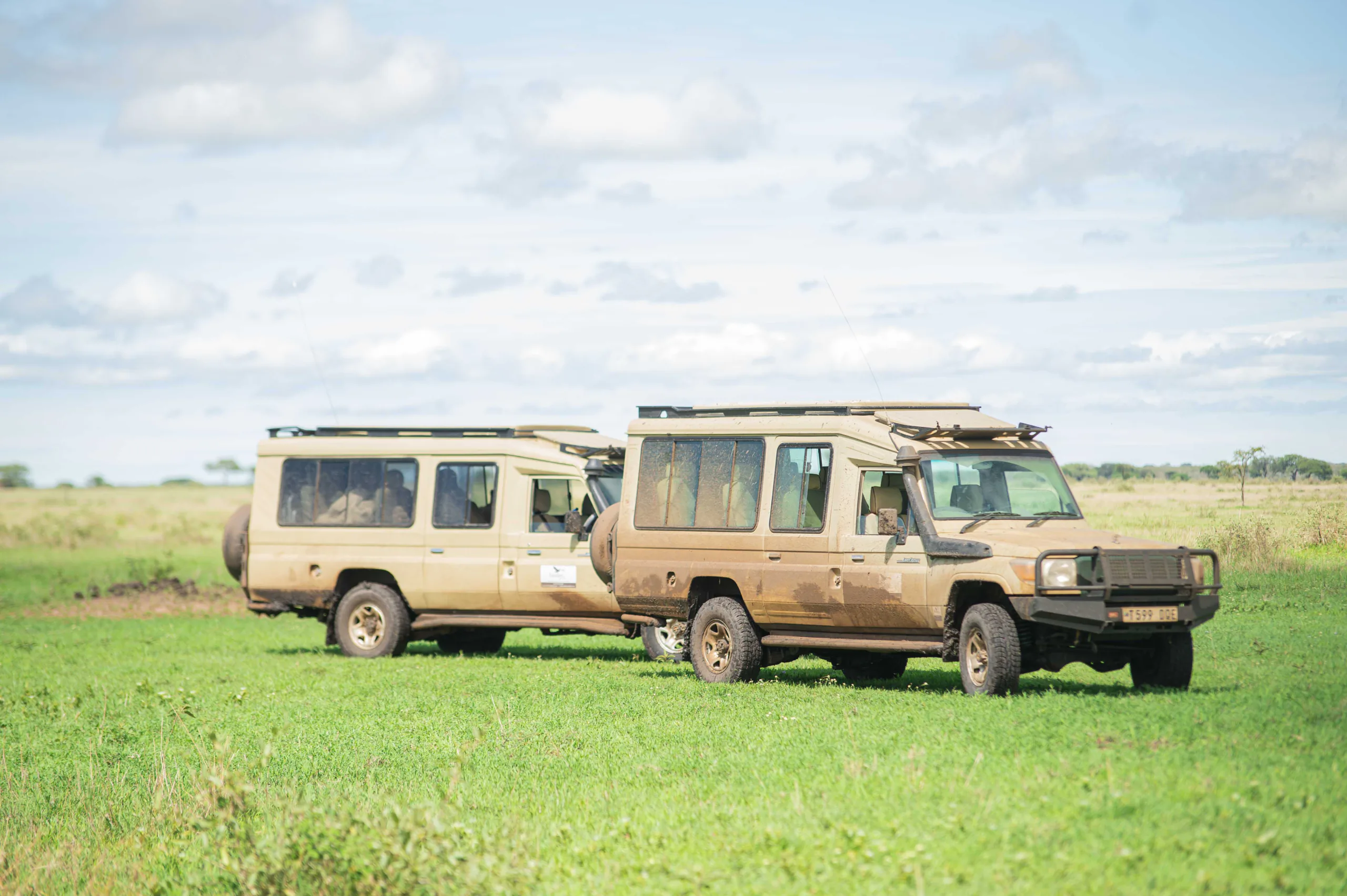 Two Excellent Guides safari Land Cruisers in open grassland